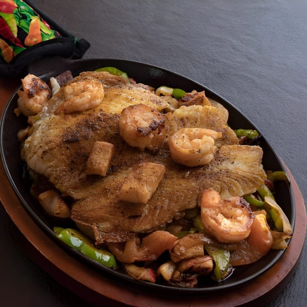 Sizzling platter of tilapia and shrimp fajitas with bell peppers and onions at Camila's Mexican Restaurant.
